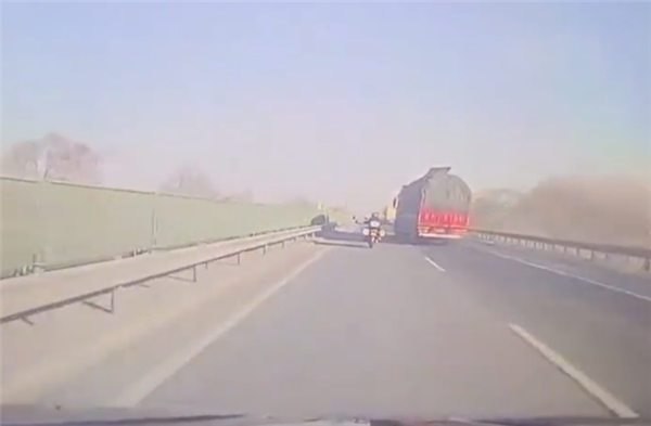 高速上摩托车和大货车斗气：被挂倒后失控摔下路基